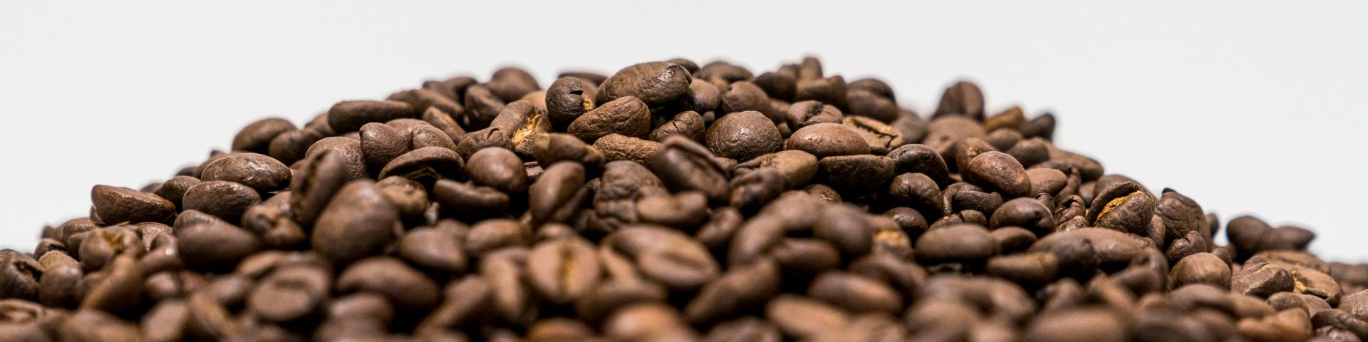 A pile of mixed coffee beans against a white background