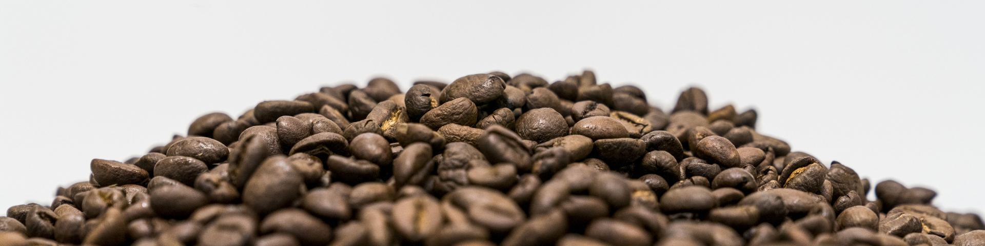A pile of mixed coffee beans against a white background