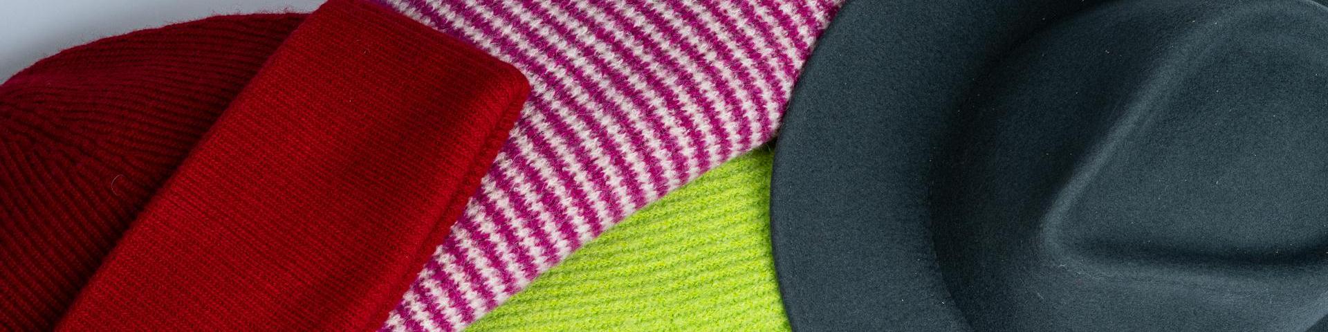 A range of hats and scarves in red, yellow, white and purple, and black