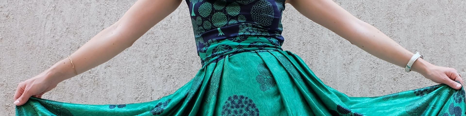 A woman standing outside in a green and purple dress