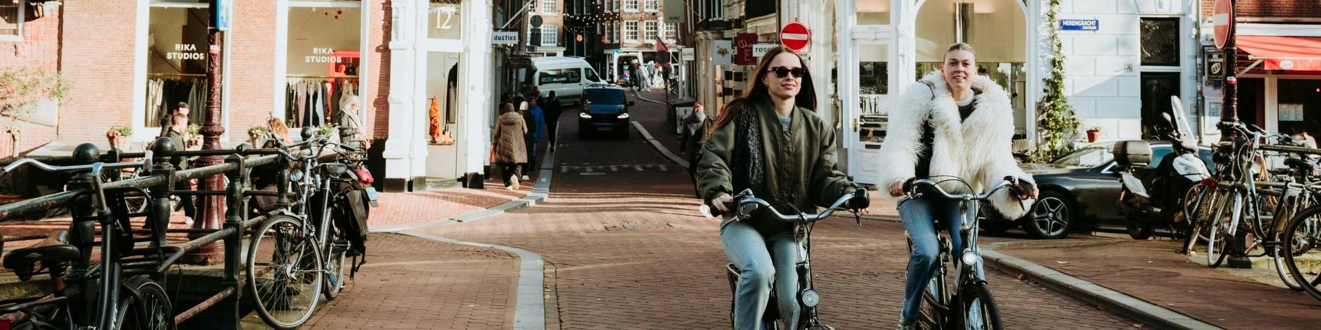 Two young women cycling in Amsterdam