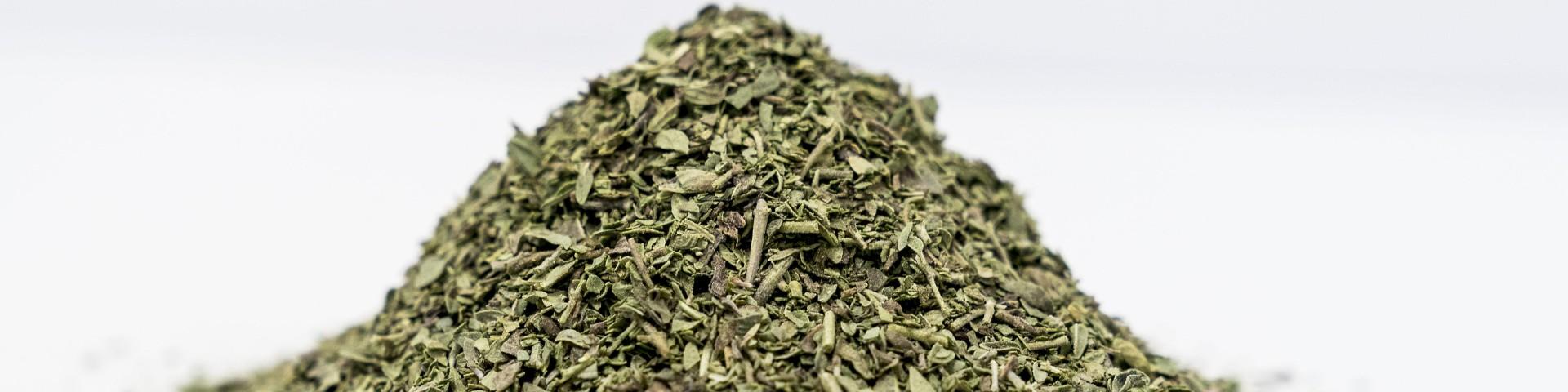 Pile of dried oregano against a white background