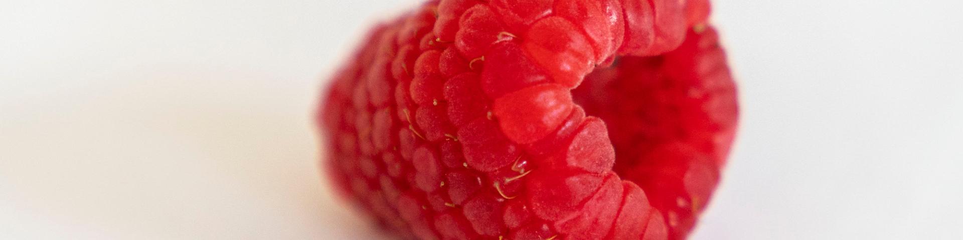 Close-up of a fresh raspberry against a white background