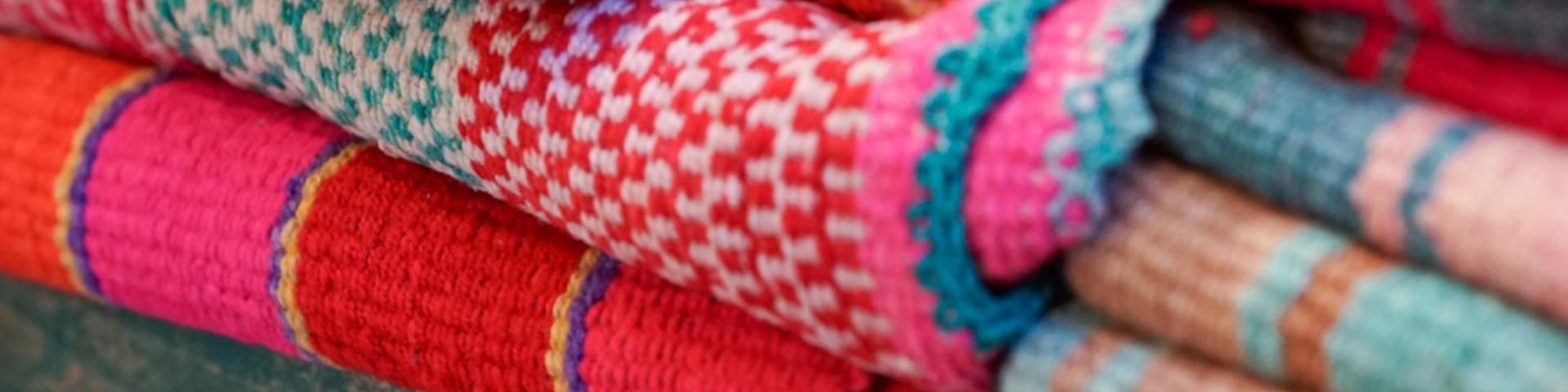 Close-up of piles of coloured rugs
