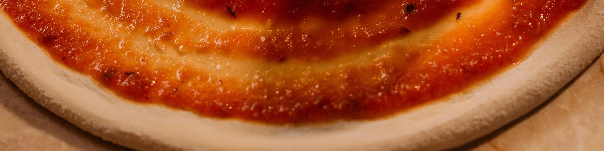 Close-up of tomato puree on a pizza base