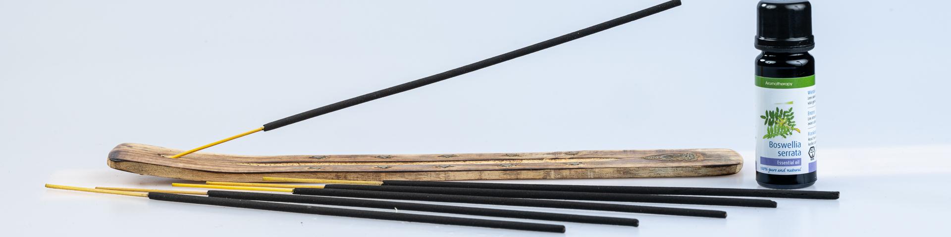 Frankincense sticks placed beside a bottle of Boswellia Serrata essential oil