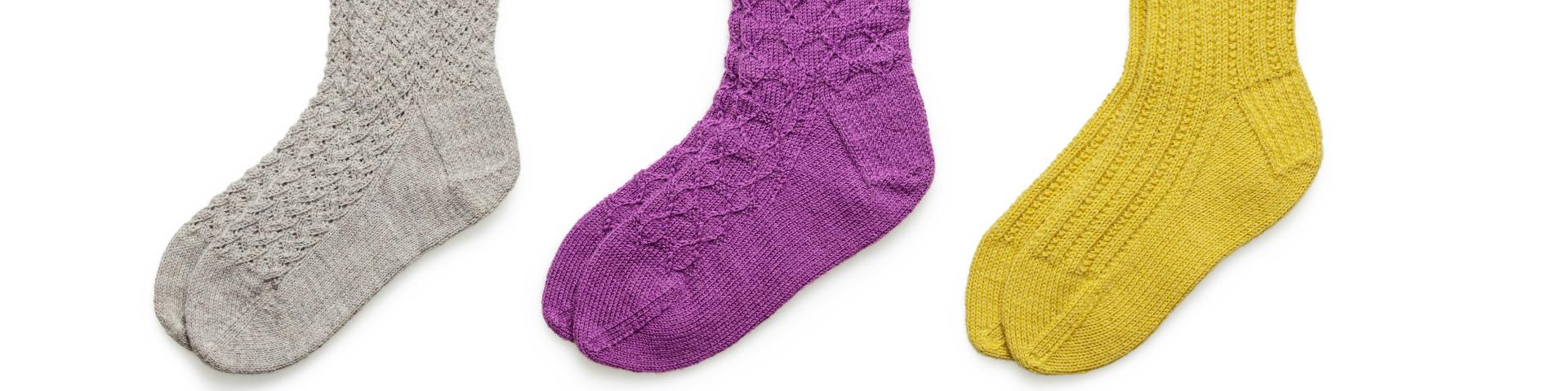 Grey, blue and yellow socks against a white background