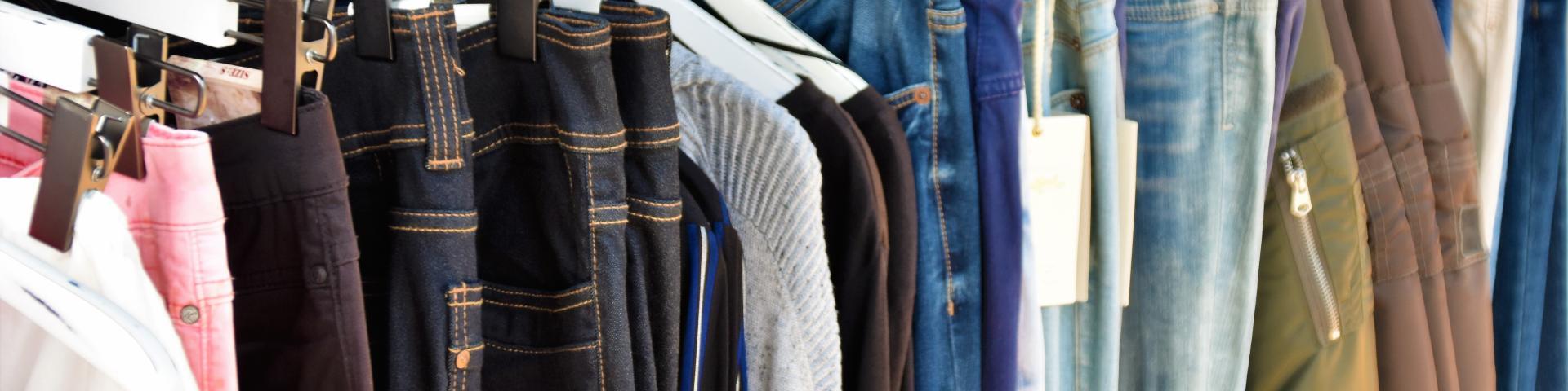 Jeans of different colours hanging on a clothing rack