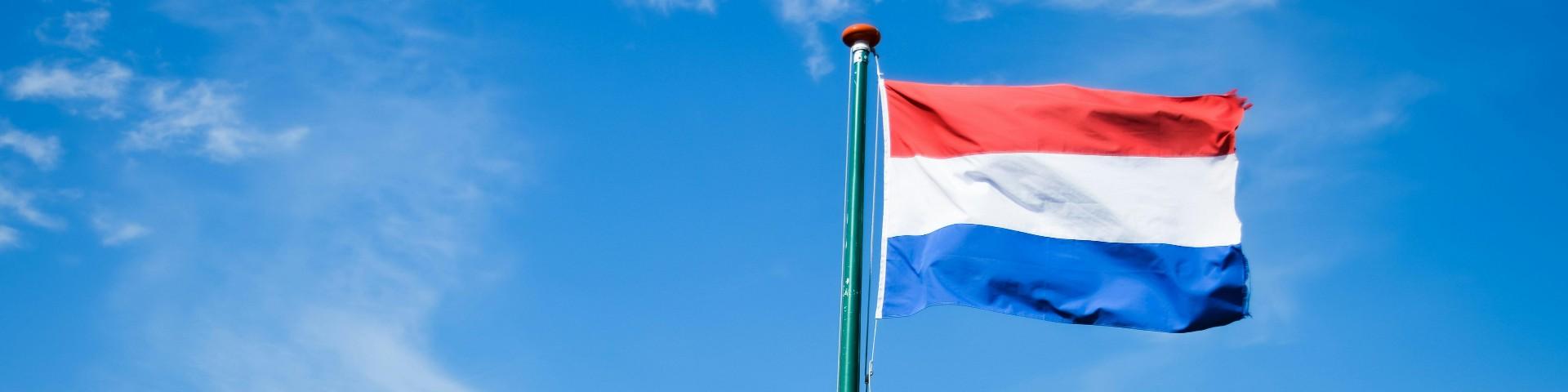 Dutch flag against a blue sky