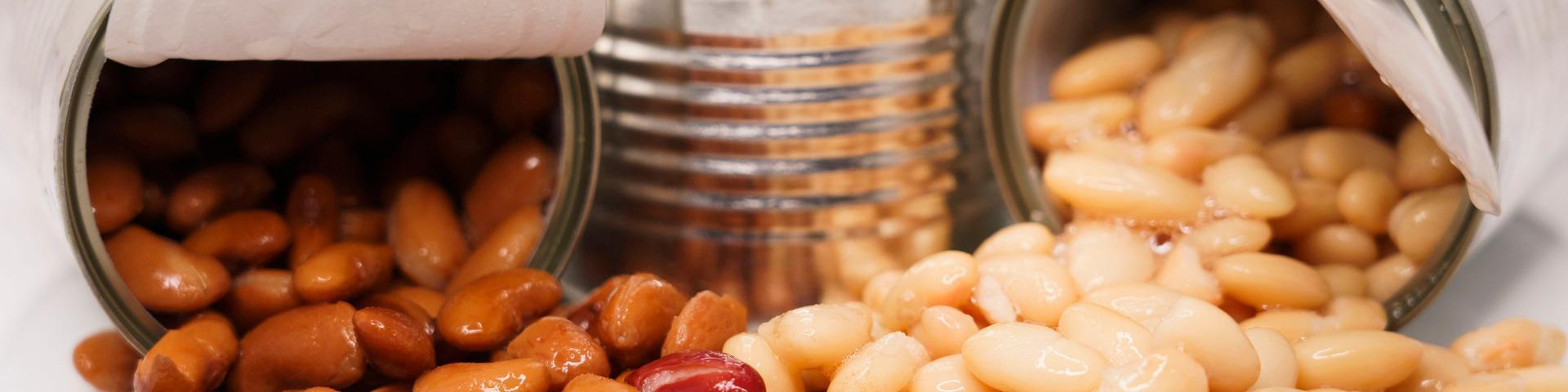 Two opened cans of beans with the beans visible in the foreground