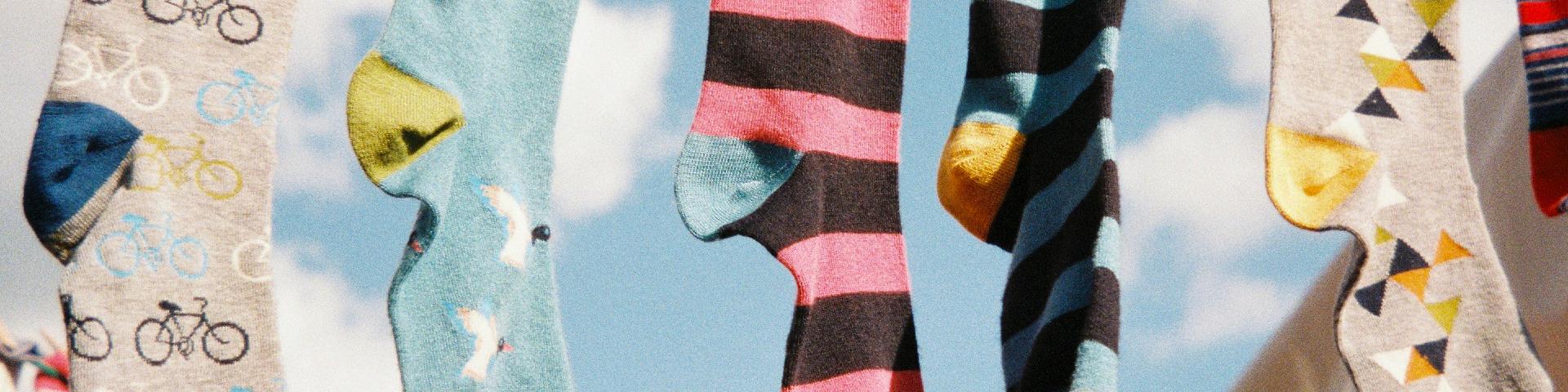 Various coloured socks hanging outdoors