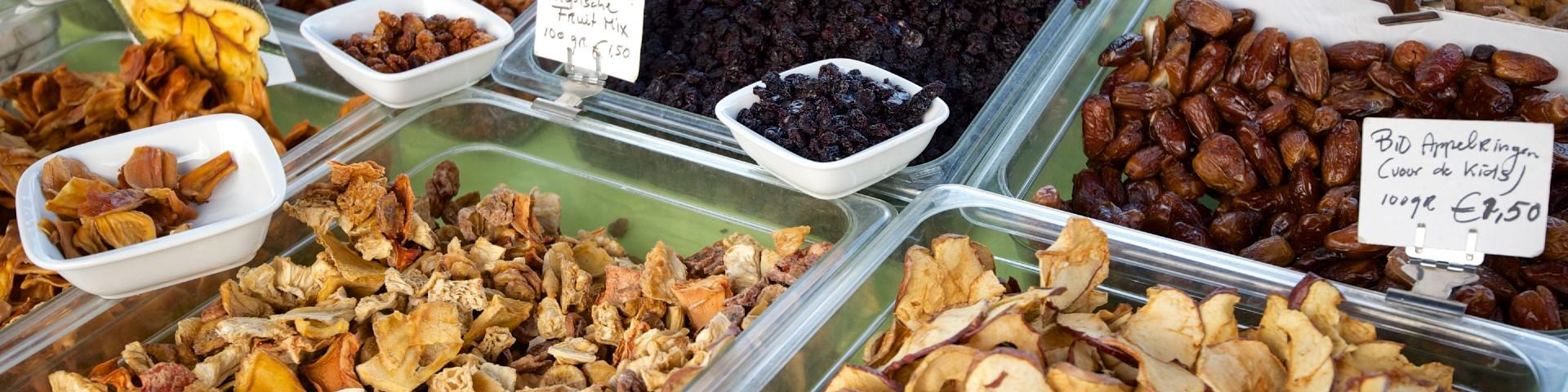 Various dried fruits in open containers with price tags