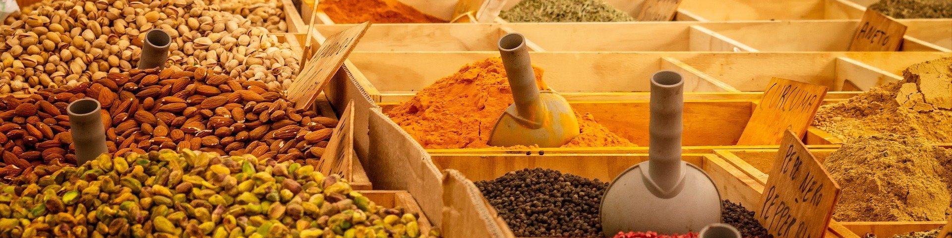 Various kinds of fresh nuts and spices laid out in wooden boxes