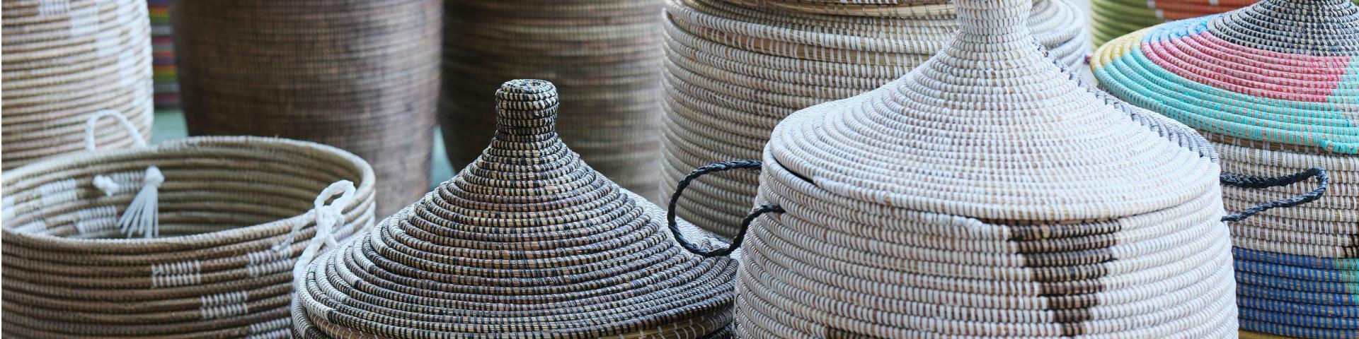 Various patterned baskets with and without lids standing on the ground
