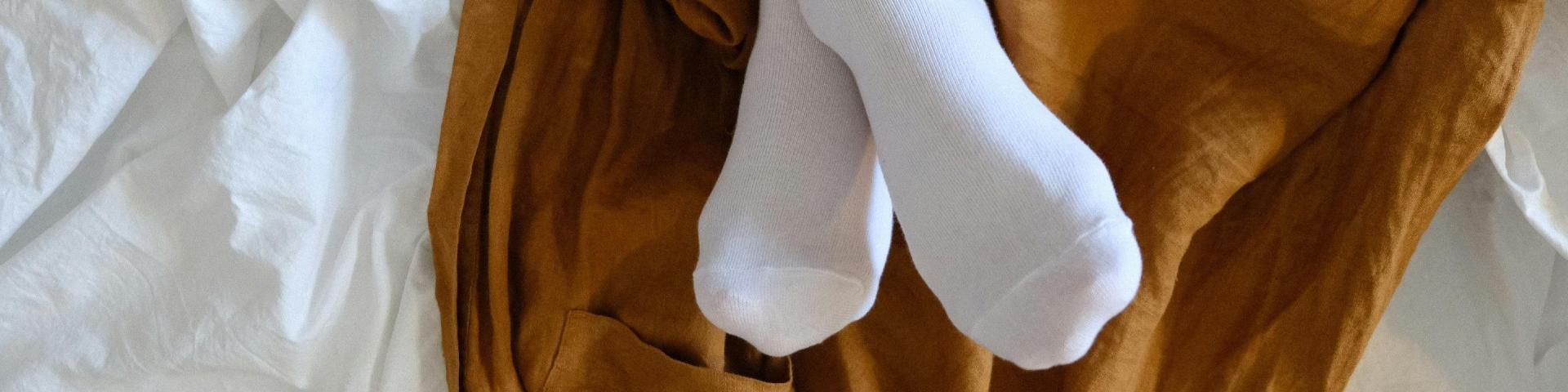 White socks worn by a woman lying on a bed