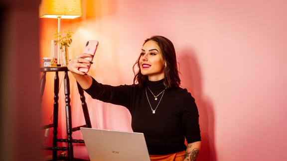 An influencer takes a selfie to post it on social media