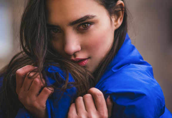 Woman wearing blue coat made from synthetic material