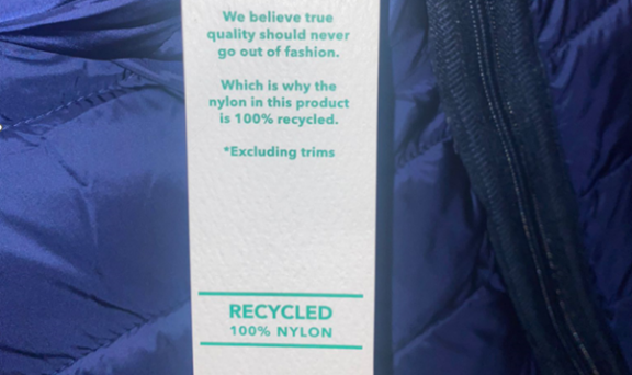 Label of a clothing item. It shows the item is made from 100% recycled nylon.