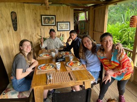 People posing around a kitchen table in a house in rural Colombia