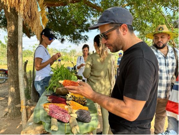 Tourists around a table filled with exotic fruit and veg