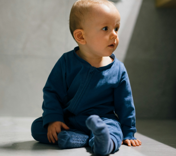 A baby wearing a blue shirt with blue pants