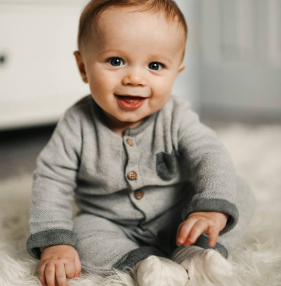 Picture of a smiling baby in grey babywear
