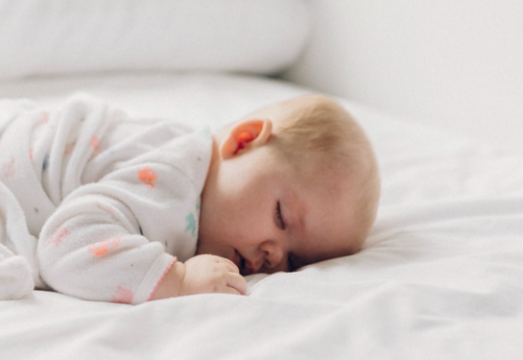 A sleeping baby in white sleepwear