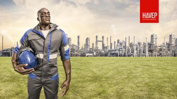 Advert for the workwear producer HAVEP, showing a black person in workwear against a grassy backdrop