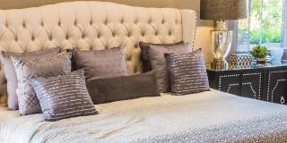 A double bed made up with bed textiles in a home bedroom