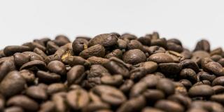 A pile of mixed coffee beans against a white background