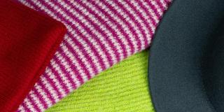 A range of hats and scarves in red, yellow, white and purple, and black