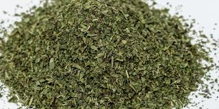 pile of dried oregano on a white surface