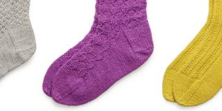 Grey, blue and yellow socks against a white background