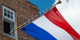 Dutch flag on a pole hanging out of a window