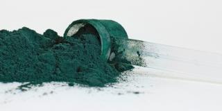 Spirulina powder alongside a dosing spoon