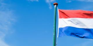 Dutch flag against a blue sky