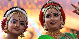 Two women dressed in traditional Indian garb, dancing