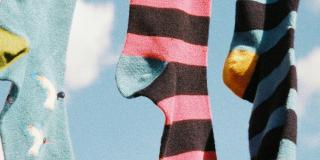Various coloured socks hanging outdoors
