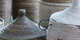Various patterned baskets with and without lids standing on the ground